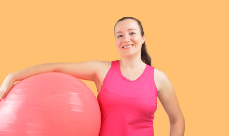 A fit young beauty with a holding a medicine ball at officeの写真素材