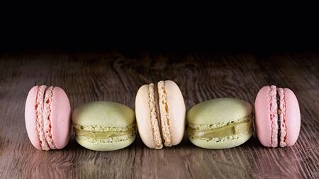 five colored macarons on wood backgroundの写真素材
