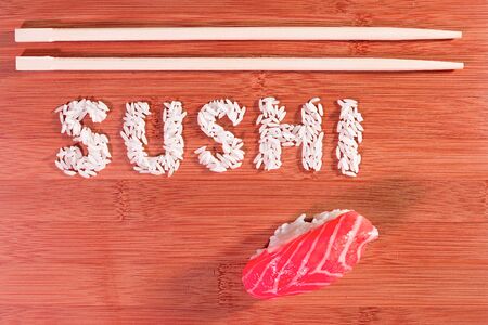sushi and sushi rice written on bamboo with chopstickの写真素材