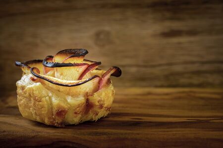 rose shaped apple dessert on wooden backgroundの写真素材