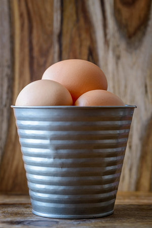 eggs in tin bucket over wood