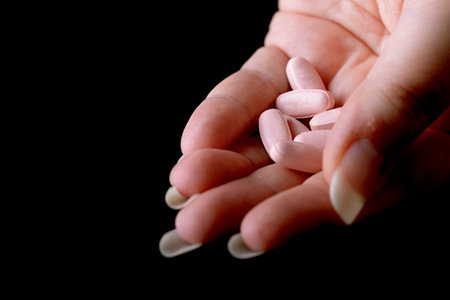 pink pills under female hand female viagraの写真素材