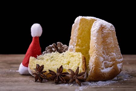 pandoro cake on wood with star anise, pine cone and hat of Santa Clausの写真素材