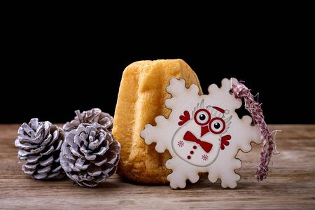 pandoro cake with pine cone and snowflake with an owl on woodの写真素材