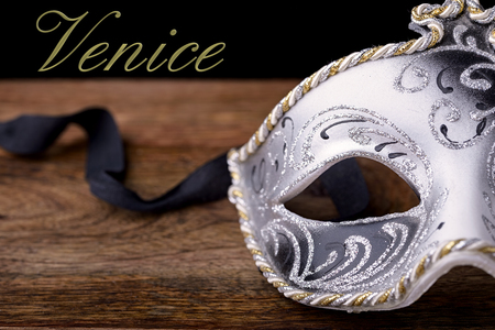 carnival mask white, black and gold on wood on a black background with Venice writtenの写真素材