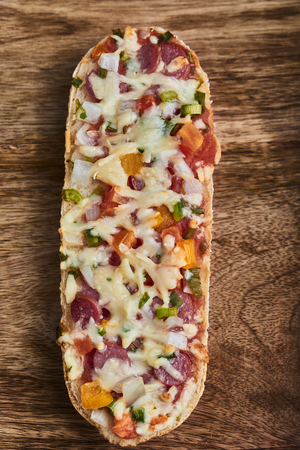 baked baguette with salami, cheese and vegetableの写真素材