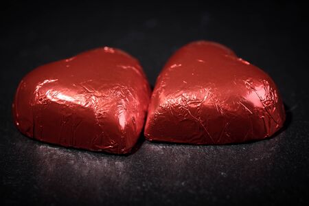 chocolates in a heart shape wrapped in red paperの写真素材