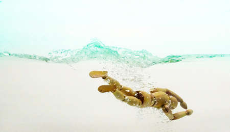 Male manikin diving through the waterの写真素材