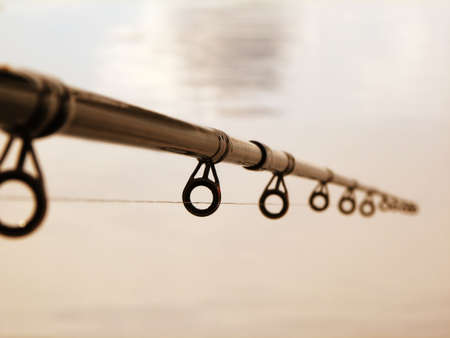 fishing rod against the water surfaceの写真素材