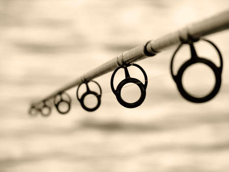 fishing rod against the water surfaceの写真素材