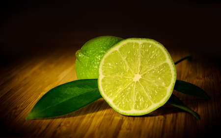 Two limes on a wooden board.の写真素材