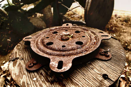Wooden wheel with rusty metal in the countrysideの写真素材