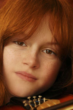 close up of red headed girl with violinの写真素材