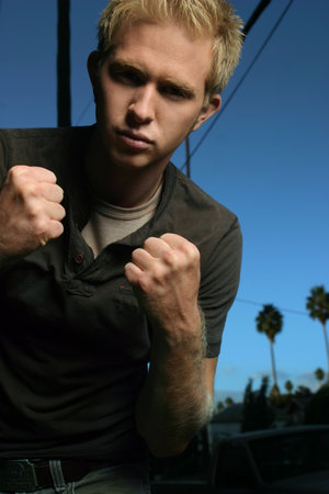 young blond male in fighting stance with blue sky