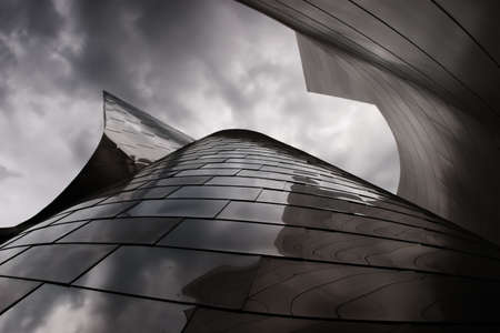 photo of modern metal building with a cloudy sky aboveの写真素材