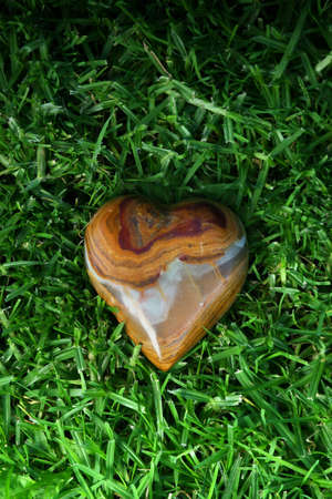 a heart made out of stone laying on grassの写真素材