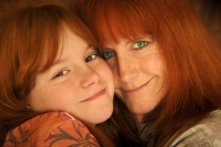 red headed mother and daughter hugging の写真素材