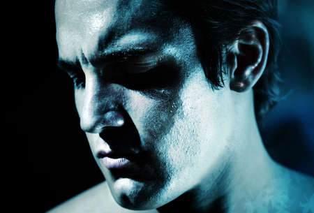 a man's face covered in ice with blue affectの写真素材