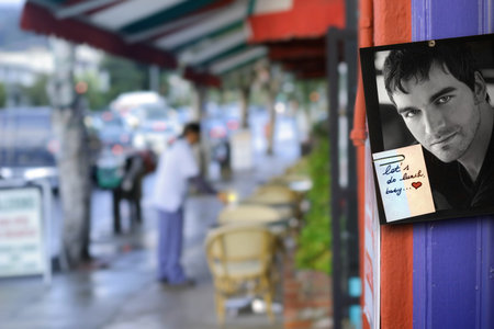 City scene with photo and note post on outdoor wall alongside cafeの写真素材