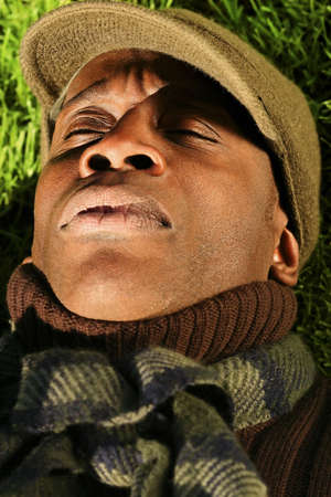 Close-up portrait of a sleeping African-American man laying in the grassの写真素材