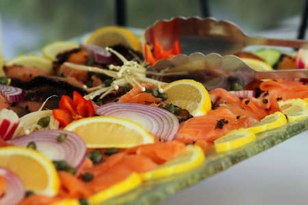 Table set for brunch with smoked salmon lox, capers, lemons, dill (shallow depth of field)の写真素材