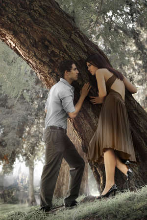 Portrait of young man and woman against treeの写真素材