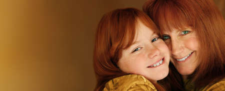 Loving portrait of smiling mother and daughter with red hair with lots of copy spaceの写真素材