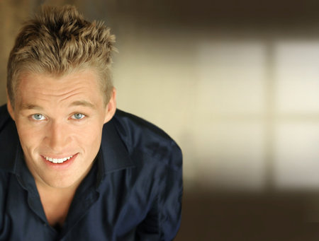 Happy young businessman smiling against neutral background with lots of copy smace