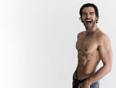 Sexy shirtless guy laughing against neautral background with lots of copy spaceの写真素材