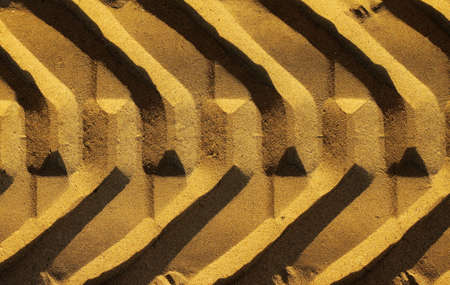 Graphic photo of a wide tire track in golden sandの写真素材