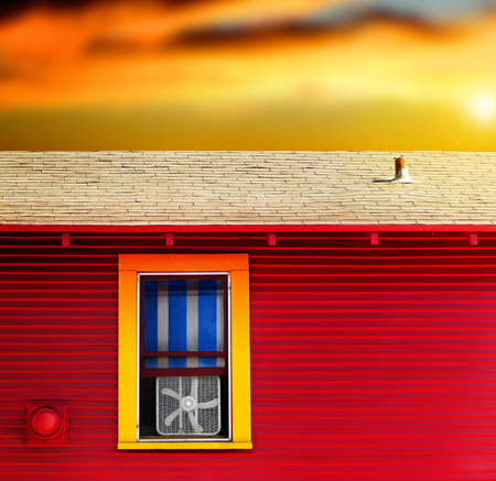 Colorful home exterior with vibrant sky featuring a little window with window fanの写真素材