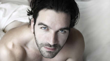 Portrait of a sexy man relaxed in bedの写真素材