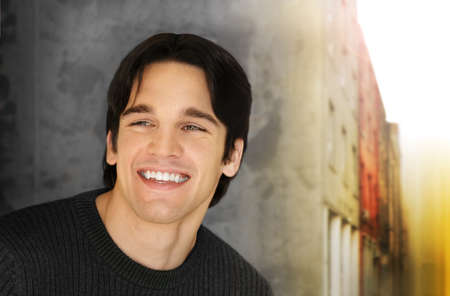 Portrait of a handsome young man with big smile against cool styled outdoor backgroundの写真素材