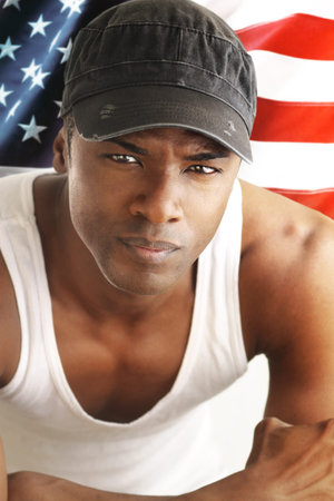 Portrait of a good looking young man against American flag backdropの写真素材