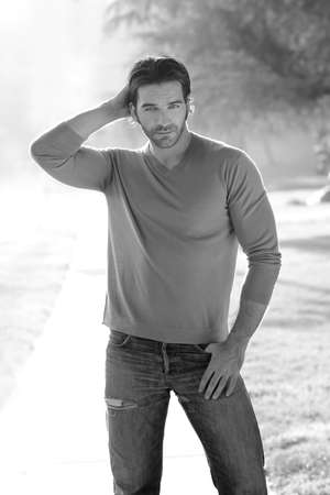 Natural black and white portrait of a classically handsome man outdoors in casual clothingの写真素材