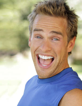 Outdoor portrait of a young man with big fun expression laughingの写真素材