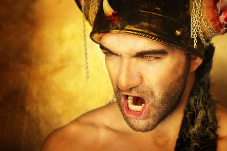 Sexy powerful warrior screaming against golden backgroundの写真素材