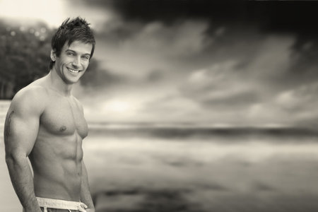 Classic outdoor portrait of a great looking shirtless muscular male model against dramatic skyscape in monochromeの写真素材