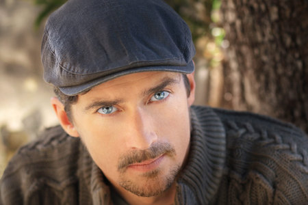 Great looking guy outdoors in sweater and trendy cap