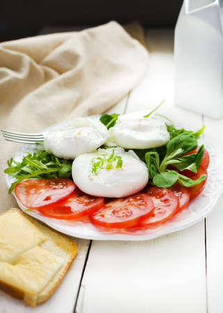 Breakfast with poached eggs seasoned with smoked saltの写真素材