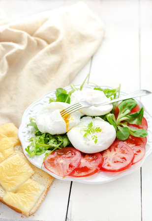 Breakfast with poached eggs seasoned with smoked saltの写真素材