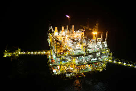oil and gas construction in night view. View from helicopter night flight. Oil and gas platform in offshoreの写真素材