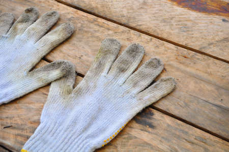 Old safety gloves on wooden background, Gloves on dirty works.の写真素材