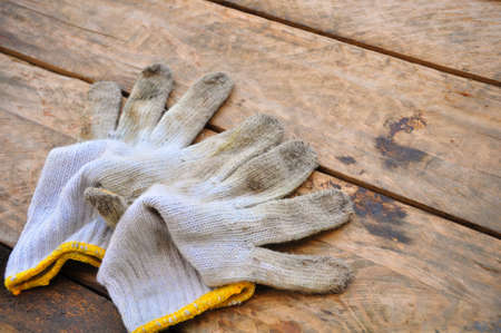 Old safety gloves on wooden background, Gloves on dirty works.の写真素材