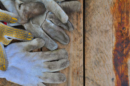 Old safety gloves on wooden background, Gloves on dirty works.の写真素材