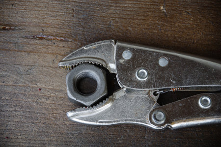 close up locking pliers on wooden background, Hand tools in work shop.の写真素材