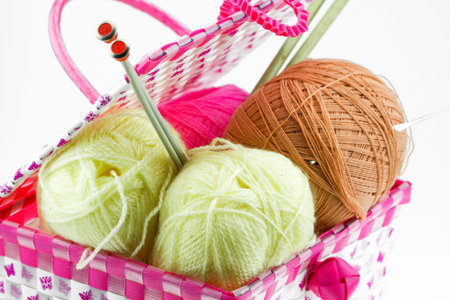 Colorful yarn balls in the basket isolated on white background