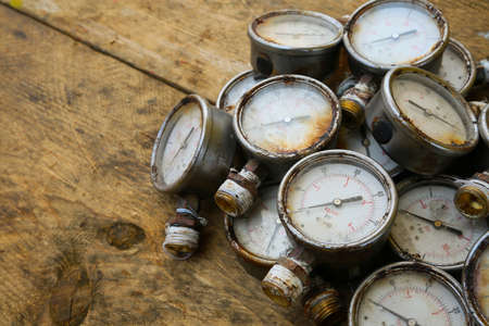 Old pressure gauge or damage pressure gauge of oil and gas industry on wooden background, Equipment of production process.の写真素材