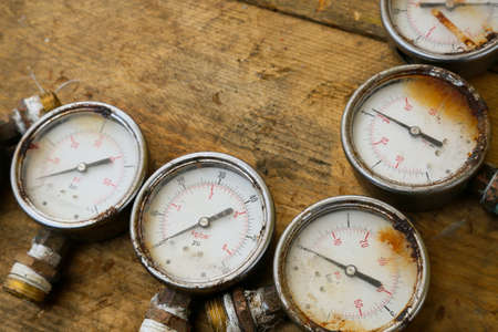 Old pressure gauge or damage pressure gauge of oil and gas industry on wooden background, Equipment of production process.の写真素材