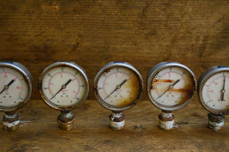 Old pressure gauge or damage pressure gauge of oil and gas industry on wooden background, Equipment of production process.の写真素材